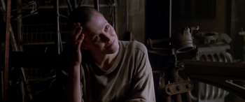 Movie still from “Alien³” (1992), directed by David Fincher – A woman with a shaved head sitting in a room; Close Up shot, Over the shoulder angle