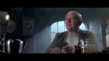 Movie still from “Alien³” (1992), directed by David Fincher – An older man sitting at a table holding a cell phone; Close Up shot, Low angle