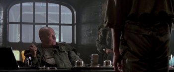 Movie still from “Alien³” (1992), directed by David Fincher – A man sitting in front of a mirror in a room; Medium shot, Over the shoulder angle