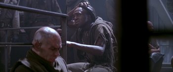 Movie still from “Alien³” (1992), directed by David Fincher – A man sitting on a chair in a dark room; Medium shot, High angle