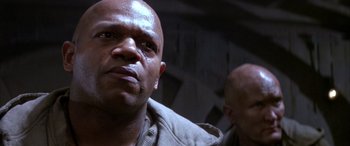 Movie still from “Alien³” (1992), directed by David Fincher – A man with a bald head is looking at the camera; Close Up shot, Low angle