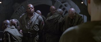 Movie still from “Alien³” (1992), directed by David Fincher – A group of men standing next to each other in a tunnel; Medium shot, Low angle