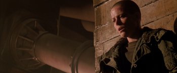 Movie still from “Alien³” (1992), directed by David Fincher – A person standing next to a wall in a room; Close Up shot, Low angle