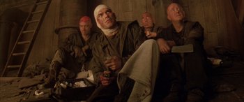 Movie still from “Alien³” (1992), directed by David Fincher – A group of men sitting next to each other; Medium shot, Low angle