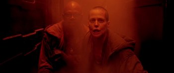 Movie still from “Alien³” (1992), directed by David Fincher – A man with a shaved head and a man with a shaved head; Medium shot, Low angle