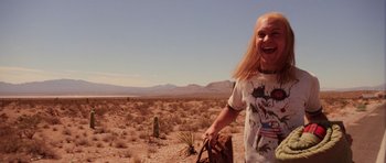 Movie still from “Fear and Loathing in Las Vegas” (1998), directed by Terry Gilliam – A man with long blonde hair is standing in the desert; Medium shot, Low angle