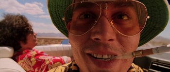 Movie still from “Fear and Loathing in Las Vegas” (1998), directed by Terry Gilliam – A person wearing glasses and a green hat; Extreme Close Up shot, Low angle