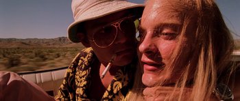 Movie still from “Fear and Loathing in Las Vegas” (1998), directed by Terry Gilliam – A man and a woman are smoking a cigarette together; Extreme Close Up shot, Low angle