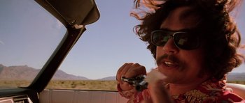 Movie still from “Fear and Loathing in Las Vegas” (1998), directed by Terry Gilliam – A man holding a camera in his mouth; Close Up shot, Low angle