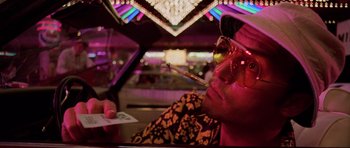 Movie still from “Fear and Loathing in Las Vegas” (1998), directed by Terry Gilliam – A man sitting in a car holding a cigarette; Close Up shot, Low angle