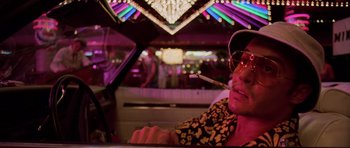 Movie still from “Fear and Loathing in Las Vegas” (1998), directed by Terry Gilliam – A man sitting in a car with a cigarette in his mouth; Close Up shot, Low angle
