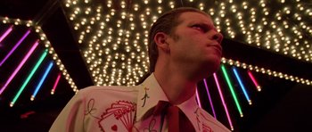 Movie still from “Fear and Loathing in Las Vegas” (1998), directed by Terry Gilliam – A man in a suit and tie looking up at the ceiling lights; Close Up shot, Low angle