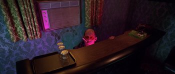 Movie still from “Fear and Loathing in Las Vegas” (1998), directed by Terry Gilliam – A man sitting at a bar with a cigarette in his mouth; Medium shot, Low angle