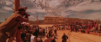 Movie still from “Fear and Loathing in Las Vegas” (1998), directed by Terry Gilliam – A group of people standing on top of a dirt field; Extreme Wide shot, High angle