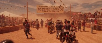 Movie still from “Fear and Loathing in Las Vegas” (1998), directed by Terry Gilliam – A group of people riding motorcycles on a dirt road; Wide shot, High angle