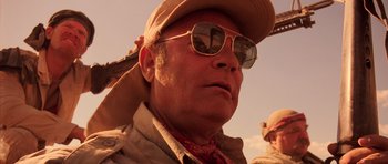 Movie still from “Fear and Loathing in Las Vegas” (1998), directed by Terry Gilliam – A person wearing sunglasses and a hat; Close Up shot, Low angle