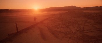 Movie still from “Fear and Loathing in Las Vegas” (1998), directed by Terry Gilliam – A person is walking in the desert at sunset; Extreme Wide shot, Low angle