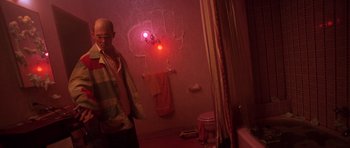 Movie still from “Fear and Loathing in Las Vegas” (1998), directed by Terry Gilliam – A man standing in front of a wall with a red light on it; Medium shot, Low angle