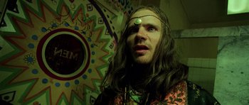 Movie still from “Fear and Loathing in Las Vegas” (1998), directed by Terry Gilliam – A man with long brown hair and a green face; Close Up shot, Low angle