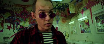 Movie still from “Fear and Loathing in Las Vegas” (1998), directed by Terry Gilliam – A man wearing a plaid shirt and purple sunglasses; Close Up shot, Low angle
