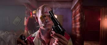 Movie still from “Fear and Loathing in Las Vegas” (1998), directed by Terry Gilliam – A man smoking a cigarette while holding a gun in his mouth; Close Up shot, Low angle