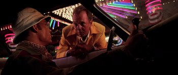 Movie still from “Fear and Loathing in Las Vegas” (1998), directed by Terry Gilliam – A man in a yellow jacket looking into a car mirror; Medium shot, Low angle