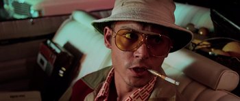 Movie still from “Fear and Loathing in Las Vegas” (1998), directed by Terry Gilliam – A person wearing a hat and sunglasses; Close Up shot, Low angle