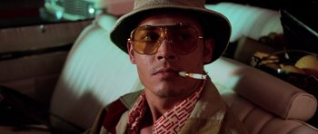 Movie still from “Fear and Loathing in Las Vegas” (1998), directed by Terry Gilliam – A man wearing a hat and sunglasses smoking a cigarette; Close Up shot, Low angle