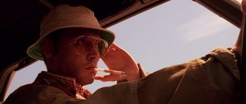 Movie still from “Fear and Loathing in Las Vegas” (1998), directed by Terry Gilliam – A man smoking a cigarette while sitting in a car; Close Up shot, Low angle