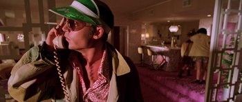 Movie still from “Fear and Loathing in Las Vegas” (1998), directed by Terry Gilliam – A man wearing a hat and sunglasses in a hotel room; Close Up shot, Low angle
