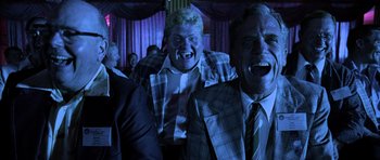 Movie still from “Fear and Loathing in Las Vegas” (1998), directed by Terry Gilliam – Two men in suits and ties are laughing together; Medium shot, Low angle