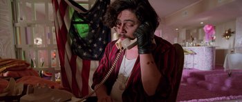 Movie still from “Fear and Loathing in Las Vegas” (1998), directed by Terry Gilliam – A man in a red and white shirt is on the phone; Medium shot, Low angle