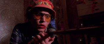 Movie still from “Fear and Loathing in Las Vegas” (1998), directed by Terry Gilliam – A man in a red hat holding a microphone; Close Up shot, Low angle