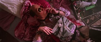 Movie still from “Fear and Loathing in Las Vegas” (1998), directed by Terry Gilliam – A man in sunglasses is sitting on the floor; Medium shot, Overhead angle