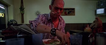 Movie still from “Fear and Loathing in Las Vegas” (1998), directed by Terry Gilliam – A man with a cigarette in his mouth eating a meal; Medium shot, Low angle