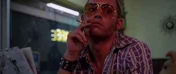 Movie still from “Fear and Loathing in Las Vegas” (1998), directed by Terry Gilliam – A man wearing sunglasses and holding a cigarette in his mouth; Close Up shot, Low angle