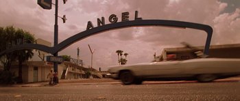 Movie still from “Fear and Loathing in Las Vegas” (1998), directed by Terry Gilliam – A car driving down a street under an arch sign; Wide shot, Low angle