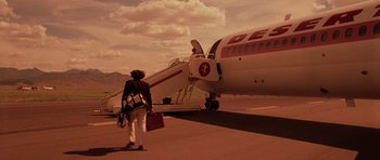 Movie still from “Fear and Loathing in Las Vegas” (1998), directed by Terry Gilliam – A woman walking towards a plane on a runway; Extreme Wide shot, Low angle
