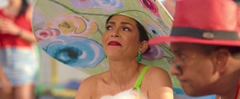 Movie still from “Fenced In” (2022), directed by Roberto Santucci – A woman in a green dress holding an umbrella; Close Up shot, High angle