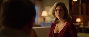 A woman in a red shirt is talking to a man