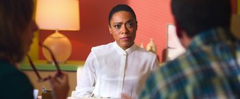 A woman in a white shirt sitting in front of a table