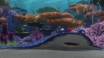 Movie still from “Finding Nemo” (2003), directed by Andrew Stanton – An underwater view of a coral reef with a blue shark; Wide shot, High angle