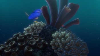 Movie still from “Finding Nemo” (2003), directed by Andrew Stanton – A blue fish swimming in the ocean next to a coral reef; Extreme Wide shot, High angle