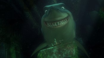 Movie still from “Finding Nemo” (2003), directed by Andrew Stanton – A smiling shark in the water with a fish in its mouth; Extreme Wide shot, Low angle