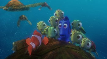 Movie still from “Finding Nemo” (2003), directed by Andrew Stanton – A group of small fish in the water next to an orange fish; Wide shot, High angle