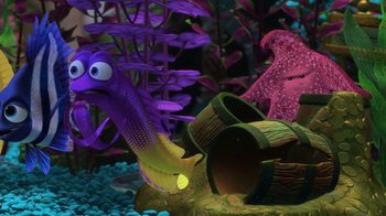 Movie still from “Finding Nemo” (2003), directed by Andrew Stanton – An aquarium with a purple and yellow fish and a barrel; Medium shot, High angle