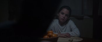 Movie still from “Firestarter” (2022), directed by Keith Thomas – A girl sitting at a table with a bowl of oranges; Close Up shot, Over the shoulder angle