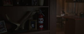 Movie still from “Firestarter” (2022), directed by Keith Thomas – A fire extinguisher and a picture on a shelf; Extreme Close Up shot, High angle