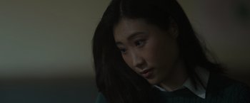 Movie still from “Firestarter” (2022), directed by Keith Thomas – A person with long black hair; Close Up shot, Over the shoulder angle