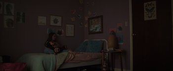Movie still from “Firestarter” (2022), directed by Keith Thomas – A girl sitting on a bed with a teddy bear in her room; Wide shot, High angle
